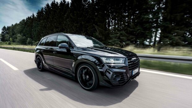 A black Audi Q7 is driving fast along a road surrounded by trees, 4K Desktop Wallpaper