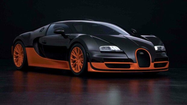 A sleek black and orange Bugatti Veyron is displayed on a dark reflective surface, HD Desktop Wallpaper