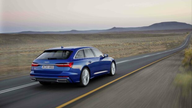 A blue Audi A6 is driving along a desert highway with mountains in the distance, 4K Desktop Wallpaper