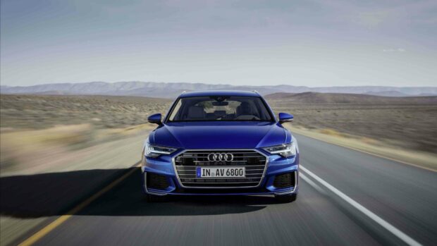 A blue Audi A6 is driving fast on a desert highway with mountains in the background, 4K Desktop Wallpaper