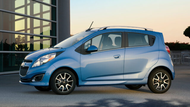 Blue Chevrolet Spark In Front Of Glass Building HD Wallpaper