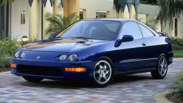 A blue Honda Integra car is parked on a paved driveway near a house with plants around, HD Desktop Wallpaper