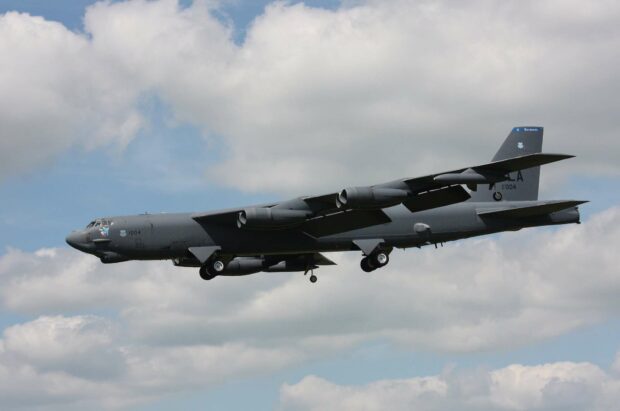A Boeing B 52 is shown flying low with its landing gear down against a cloudy sky, HD Desktop Wallpaper