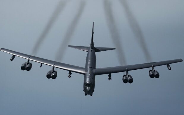 A Boeing B 52 releases exhaust trails as it flies through a cloudy sky, 2K Desktop Wallpaper