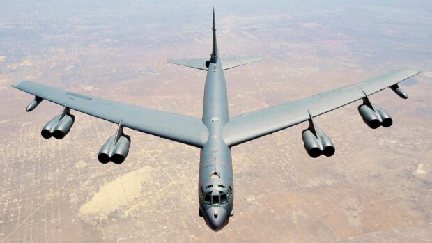 A Boeing B 52 is flying high above a desert landscape with clear skies, HD Desktop Wallpaper