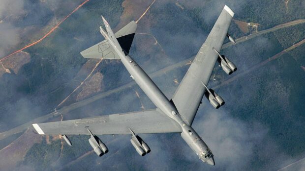 A Boeing B 52 flies above a forested area with clouds nearby, HD Desktop Wallpaper