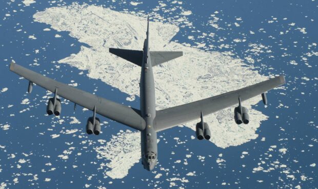 A Boeing B 52 is captured flying high above icy waters and floating icebergs, HD Desktop Wallpaper