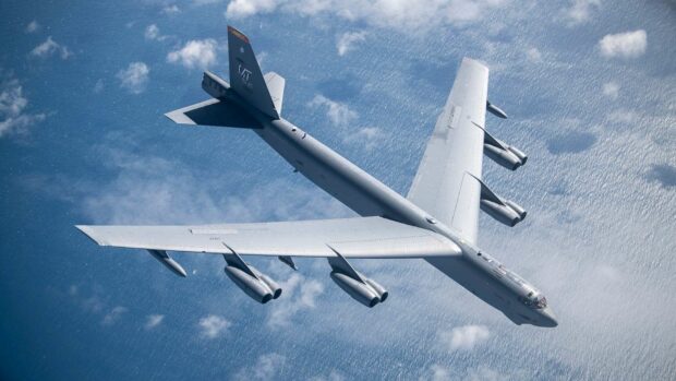 A Boeing B 52 aircraft is flying high above the ocean with clouds below, HD Desktop Wallpaper