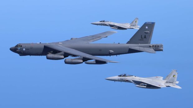 A Boeing B 52 is flying alongside two fighter jets against a clear blue sky, 4K Desktop Wallpaper