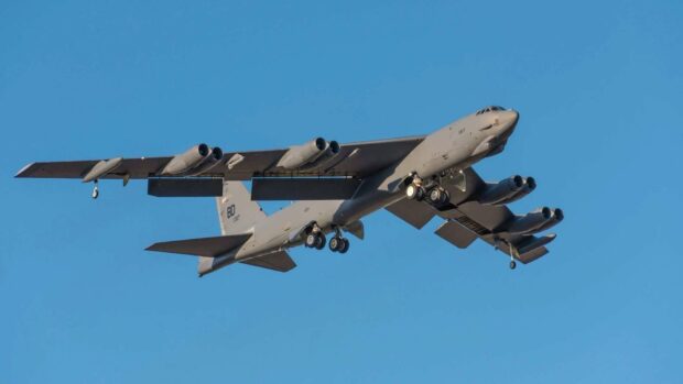 A Boeing B 52 is flying with landing gear deployed against a clear blue sky, HD Desktop Wallpaper