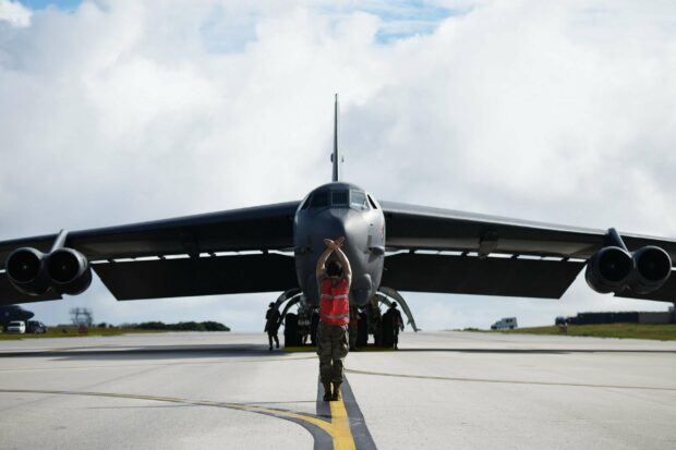 A person guides a Boeing B 52 on the runway under a cloudy sky, 2K Desktop Wallpaper