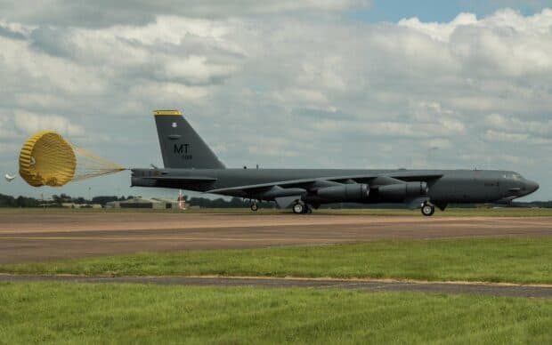 A Boeing B 52 aircraft is shown landing on a runway with its parachute deployed to slow down, HD Desktop Wallpaper