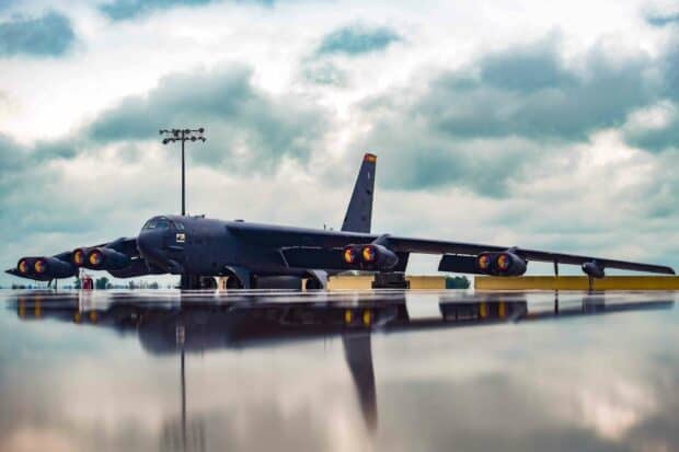 A Boeing B 52 aircraft is parked on a wet runway under a cloudy sky, HD Desktop Wallpaper