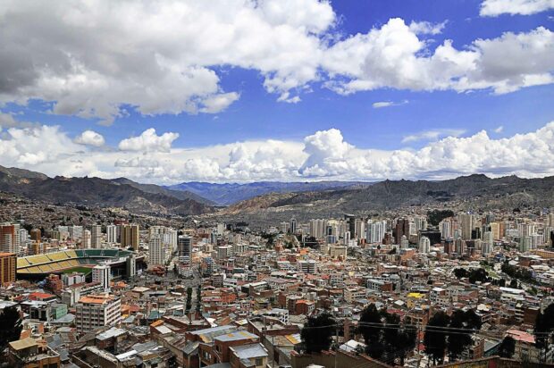 A wide view of a Bolivia city with mountains in the background under a partly cloudy sky, HD Desktop Wallpaper