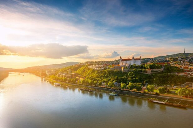 A scenic view of Bratislava featuring the castle and Danube River during sunset, HD Desktop Wallpaper