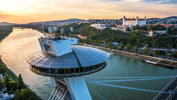 A stunning view of Bratislava with the UFO Observation Tower over the Danube River and Bratislava Castle in the background, 2K Desktop Wallpaper