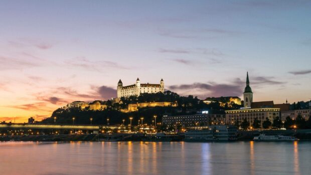 The Bratislava Wallpapers display a beautiful view of the castle and river during sunset, HD Desktop Wallpaper