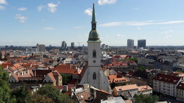 A view of Bratislava featuring the historic church tower amidst the city skyline, 2K Desktop Wallpaper