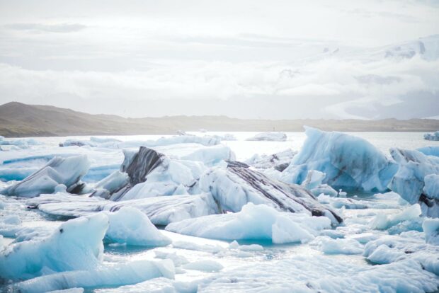 The photo shows bright arctic landscapes with icebergs floating on water under a cloudy sky, HD Desktop Wallpaper