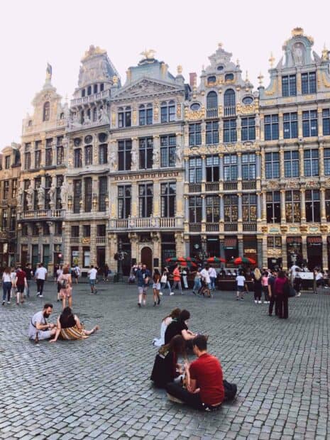 People are enjoying the lively atmosphere at a Brussels city square with ornate historic buildings, 2K Mobile Wallpaper