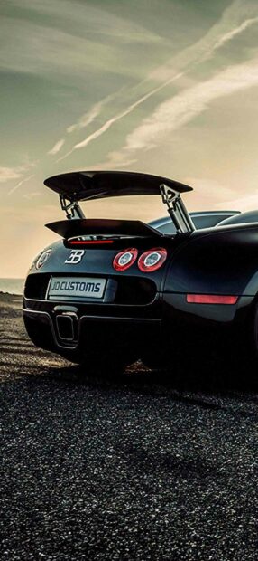 The Bugatti Veyron is shown from the rear with its spoiler raised against a cloudy sky, HD Mobile Wallpaper