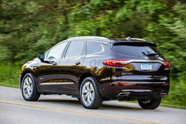 A black Buick Enclave is driving along a countryside road surrounded by greenery, 2K Desktop Wallpaper