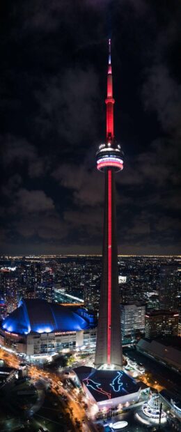 The CN Tower in Canada is illuminated in red and white against the night sky, 2K Phone Wallpaper