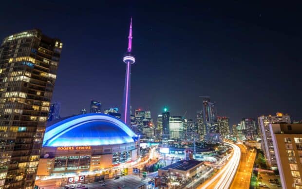 The CN Tower Canada Wallpapers shine brightly over Toronto's night skyline featuring the Rogers Centre arena