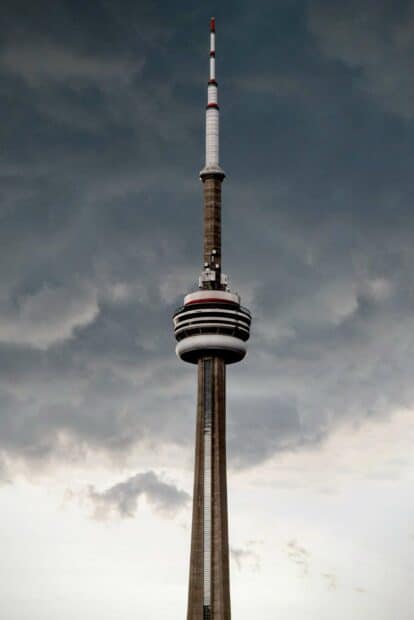 The CN Tower in Canada stands tall under a cloudy sky in this cityscape, 2K Mobile Wallpaper