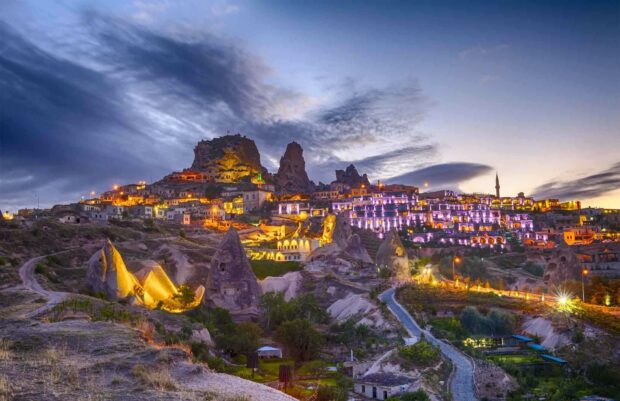 The Cappadocia landscapes show illuminated rock formations and buildings during twilight, HD Desktop Wallpaper