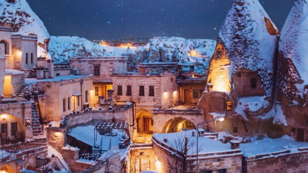 The Cappadocia village is covered in snow under a starry night sky, 4K Desktop Wallpaper
