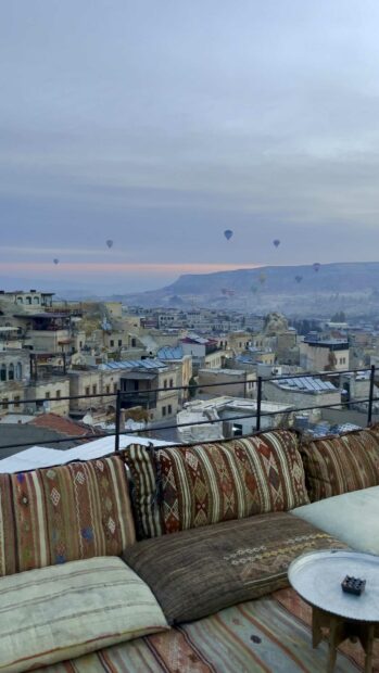 A scenic view of Cappadocia with hot air balloons floating above the historic town, 4K Mobile Wallpaper