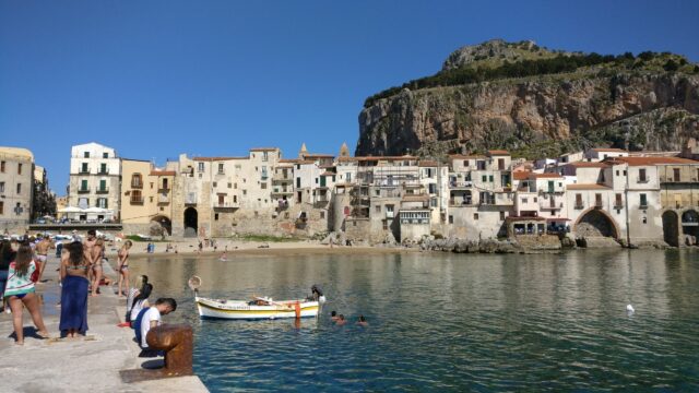 Cefalu Coastal View With Historic Buildings And Beachfront Scene