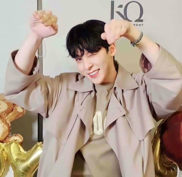 Jeong Yun Ho is smiling and raising his fists playfully in a beige outfit, HD Mobile Wallpaper