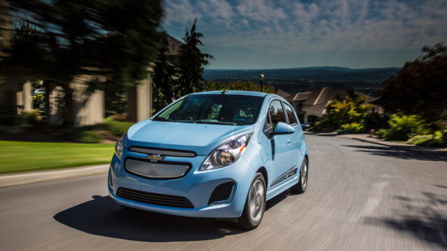 Chevrolet Spark Driving Through Scenic Road Wallpaper