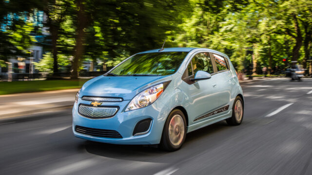 Chevrolet Spark In Motion On Tree Lined Street Wallpaper