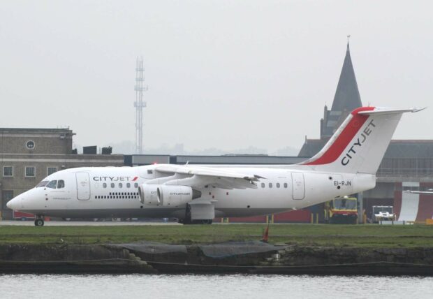 A CityJet Avro aircraft is parked on the tarmac near a grassy area by the water, HD Desktop Wallpaper
