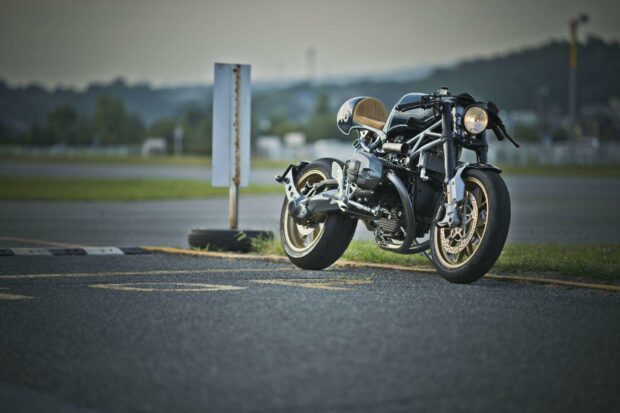 A classic BMW R Nine T motorcycle is parked on an asphalt surface with a blurred background, HD Desktop Wallpaper