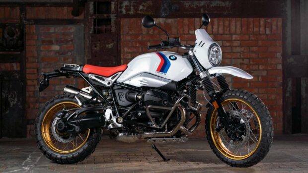 A white BMW R Nine T motorcycle with a red seat and gold wheels is parked indoors against a brick wall, HD Desktop Wallpaper
