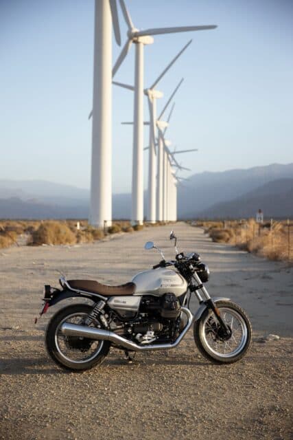 Classic Moto Guzzi V7 Motorcycle Parked Near Wind Turbines Wallpaper