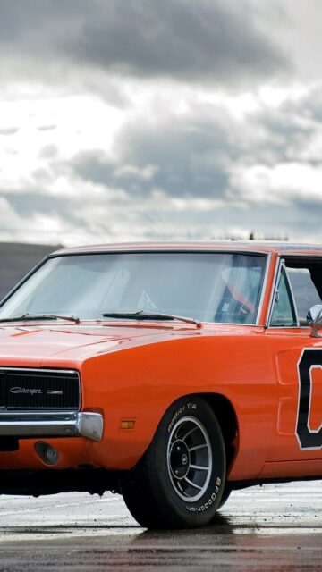 Classic Orange General Lee Dodge Charger Car Wallpaper on Wet Road with Cloudy Sky Background