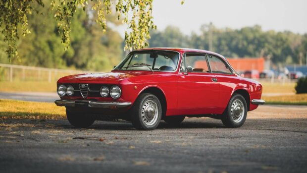 A classic red Alfa Romeo car is parked on a road surrounded by trees, HD Desktop Wallpaper