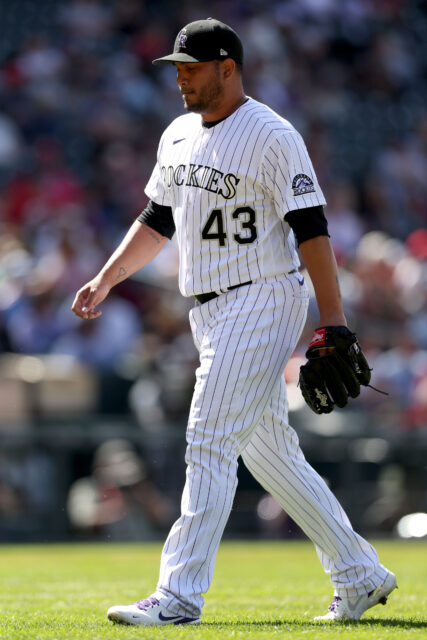 Colorado Rockies Player Walking on Field in White Pinstripe Uniform Wallpaper