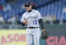 Colorado Rockies Player Wearing Number 13 on Field with Glove Baseball Wallpaper