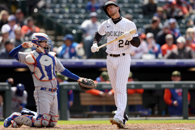 Colorado Rockies batter reacts during game against opposing catcher in MLB stadium wallpaper