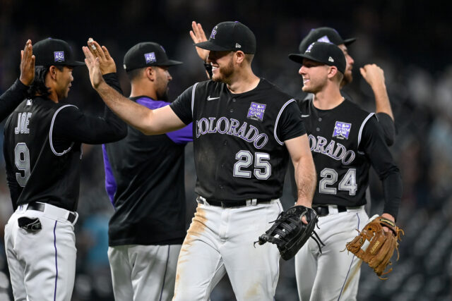 Colorado Rockies players celebrating during baseball game in black All Star jerseys wallpaper