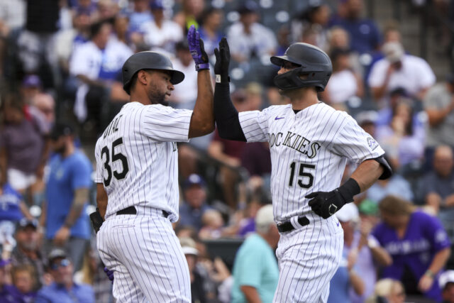 Colorado Rockies players high five celebration during baseball game action wallpaper