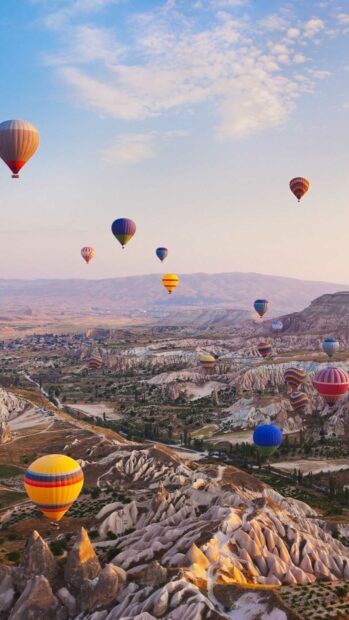 Hot air balloons float above unique rock formations in Cappadocia landscapes, HD Phone Wallpaper