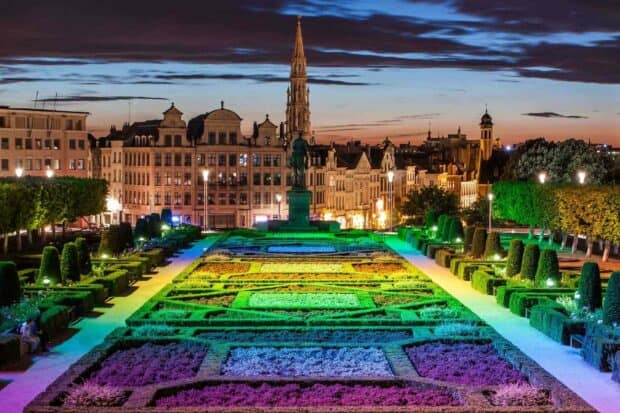A beautiful garden in Brussels is illuminated with colorful lights at dusk featuring historic buildings in the background, HD Desktop Wallpaper