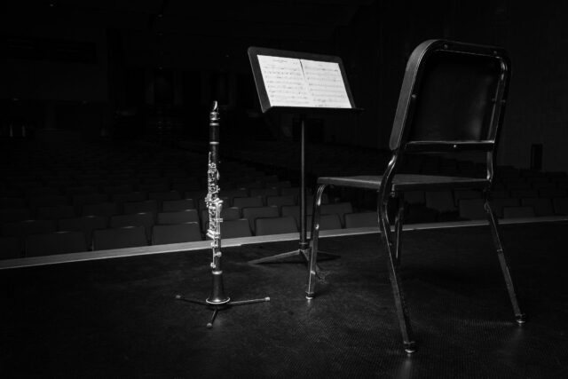 Concert Stage Clarinet With Sheet Music Background